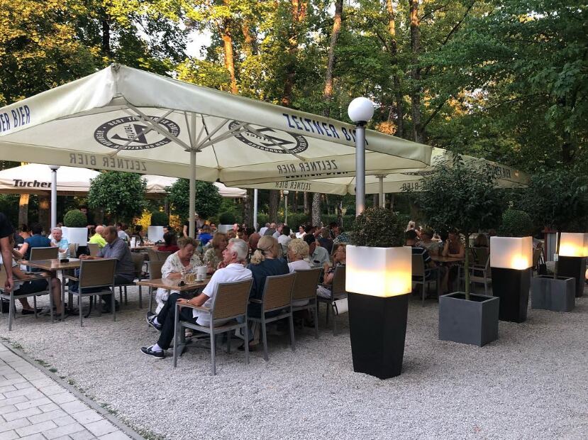 Biergarten unter Schirmen und Bäumen